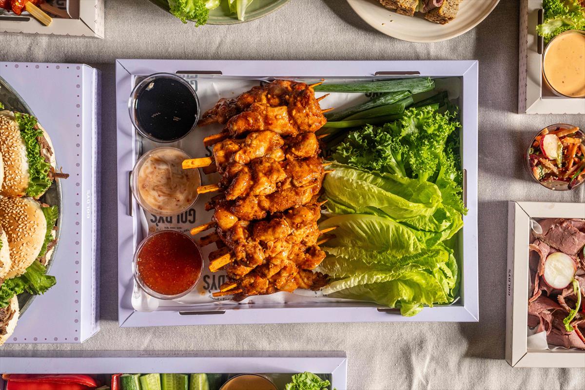 A tray of bonelss chicken leg sauté skewers in peanut butter tempura