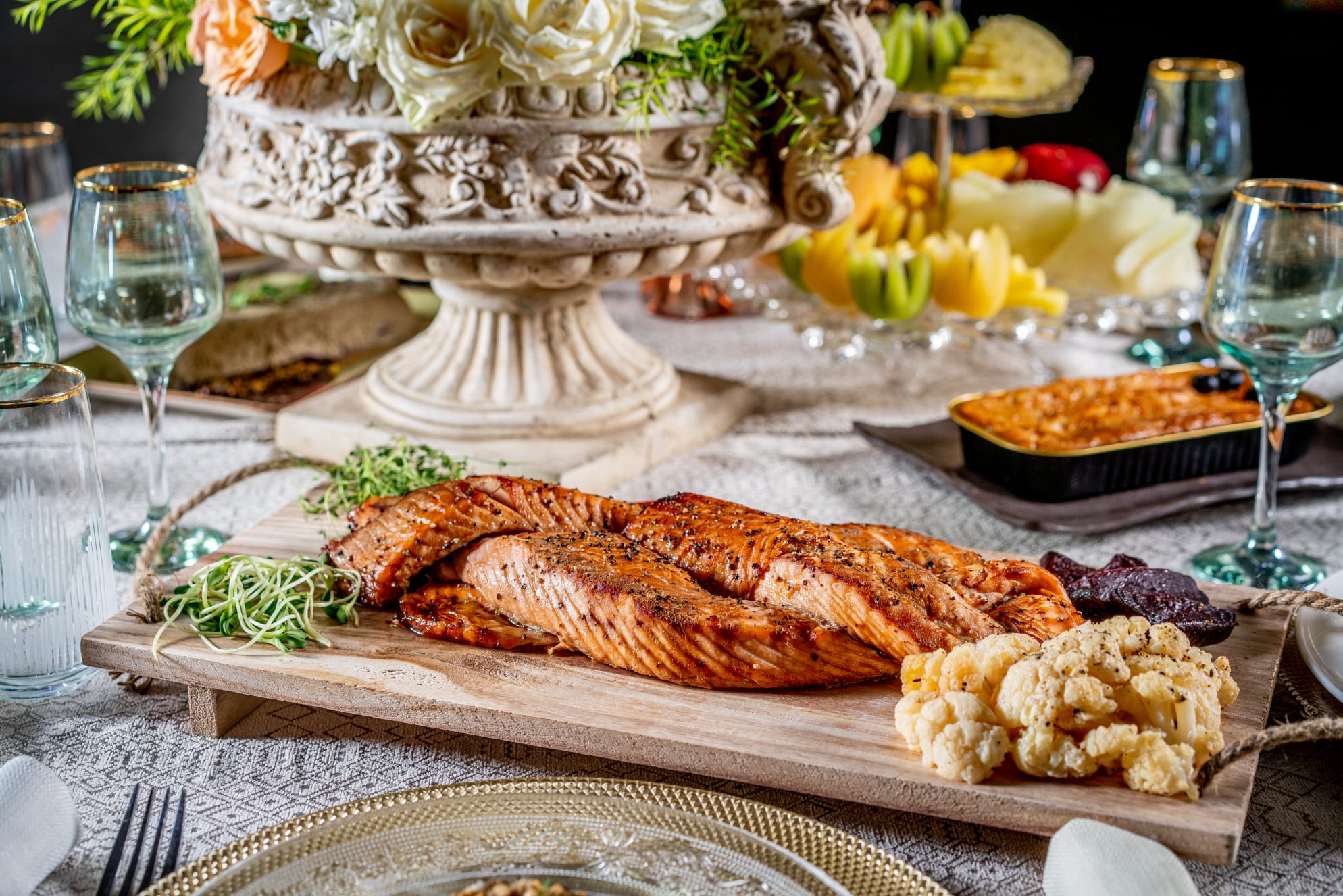 A giant salmon challah served on a wooden butcher board.